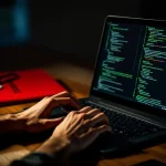Cybersecurity professional typt code op laptop met penetratietest documenten op bureau, dramatische belichting