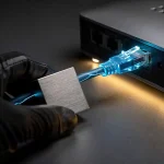 Gehandschoende hand met hangslot bij verlichte ethernetkabel in router, symboliseert netwerkbeveiliging in dramatisch amberkleurig licht.