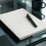 Formele gegevensverwerkingsovereenkomst op glazen bureau met pen en ingeperst slotje, kantoorverlichting, professionele sfeer.